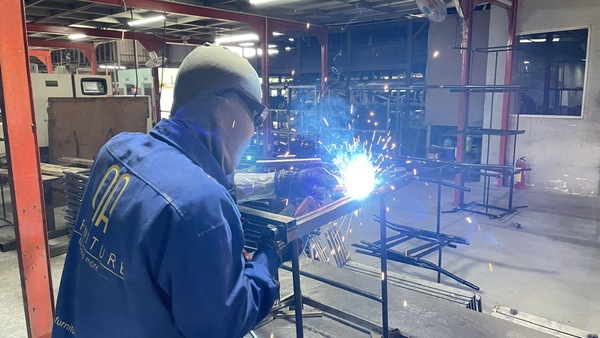 QA Furniture employees are welding metal components