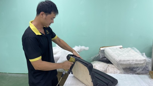 QA Furniture technical staff are meticulously upholstering the furniture frame at the furniture workshop